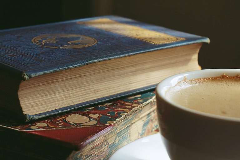 zwei alte Bücher und ein Milchkaffee